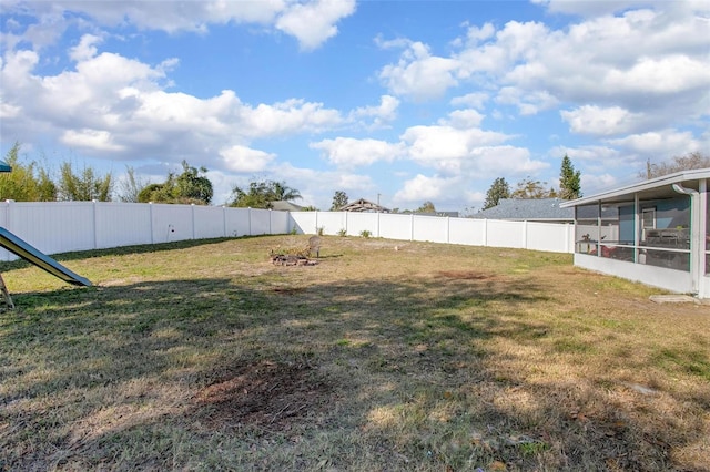 view of yard featuring a sunroom and a fenced backyard