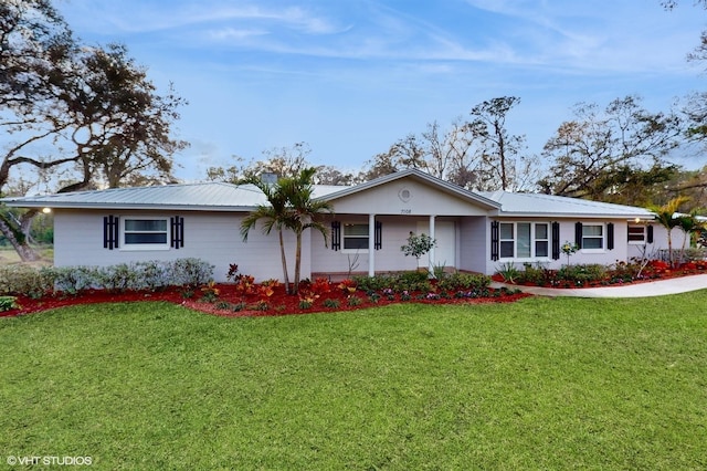 ranch-style house with metal roof and a front lawn