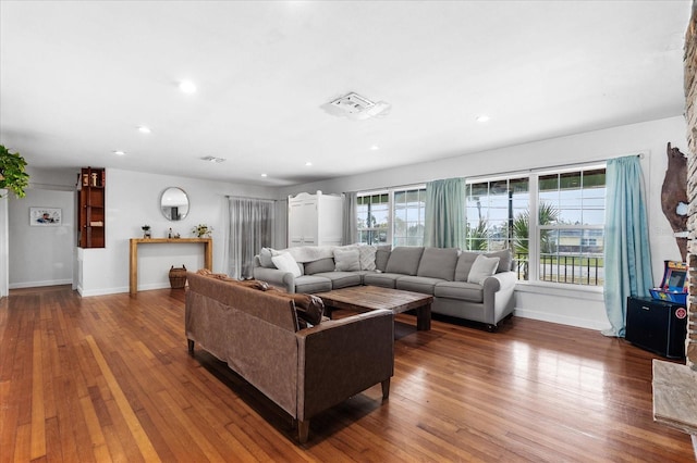 living area with hardwood / wood-style floors, recessed lighting, visible vents, and baseboards