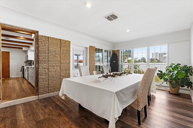 dining room featuring plenty of natural light, visible vents, and dark wood-type flooring