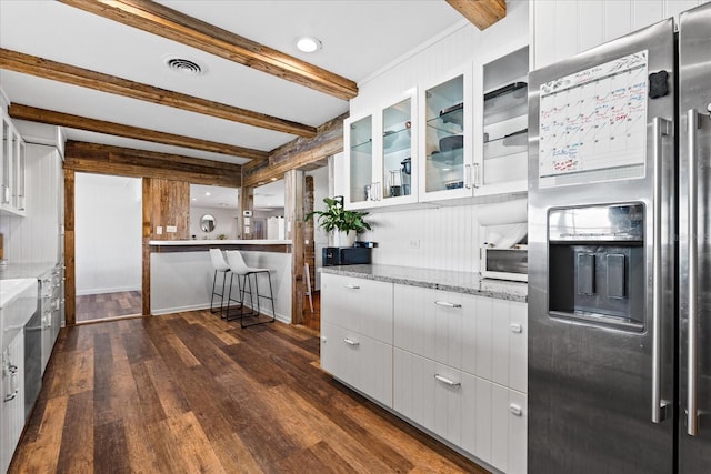 kitchen with dark wood-style floors, beam ceiling, visible vents, and stainless steel fridge with ice dispenser