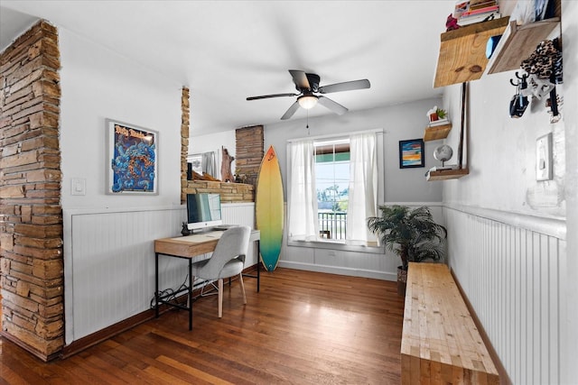 interior space with a wainscoted wall, wood-type flooring, and ceiling fan