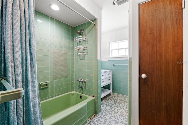 full bathroom featuring shower / tub combo, visible vents, wainscoting, tile patterned floors, and tile walls