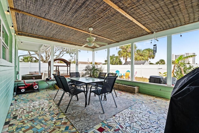 sunroom featuring a ceiling fan