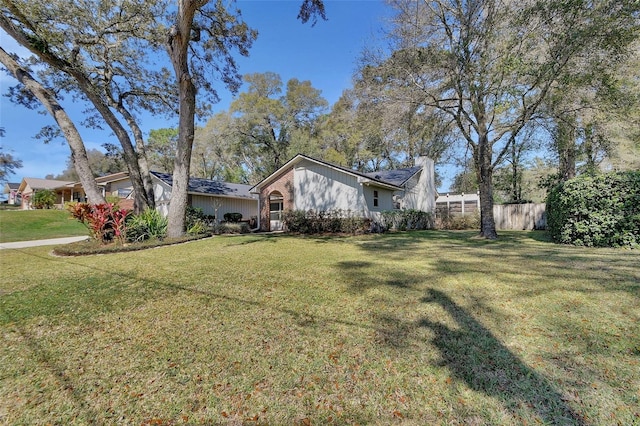 exterior space with a chimney, fence, and a front yard