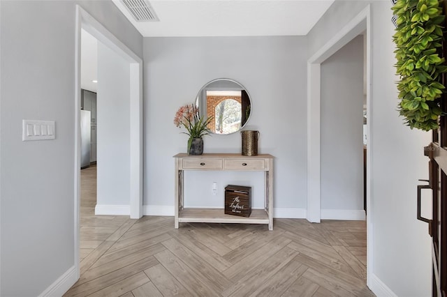 hall featuring visible vents and baseboards