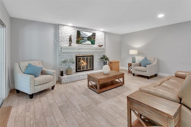 living area with recessed lighting, a fireplace, light wood-style flooring, and baseboards