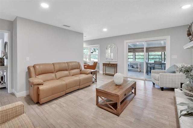 living area with light wood-type flooring, baseboards, visible vents, and recessed lighting