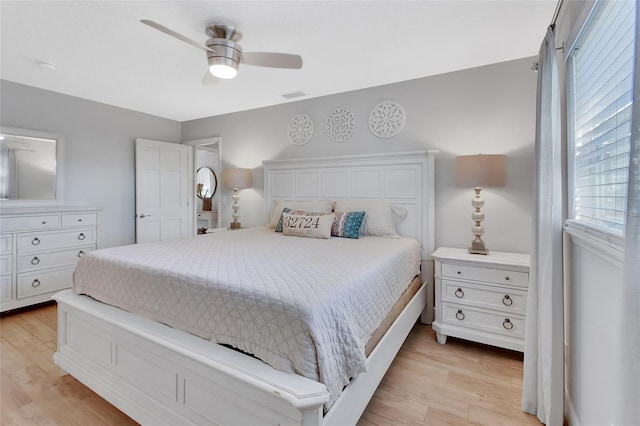 bedroom featuring a ceiling fan, visible vents, and light wood finished floors