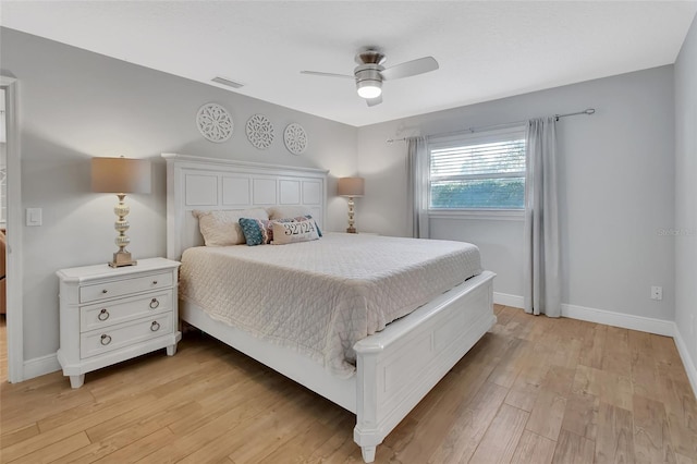 bedroom featuring a ceiling fan, light wood-type flooring, visible vents, and baseboards