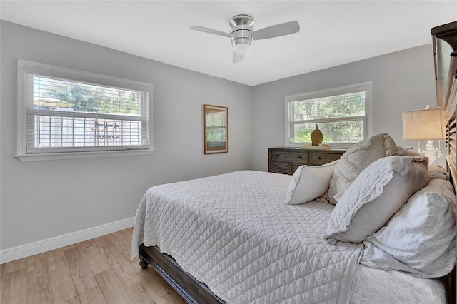 bedroom with light wood-style floors, ceiling fan, and baseboards