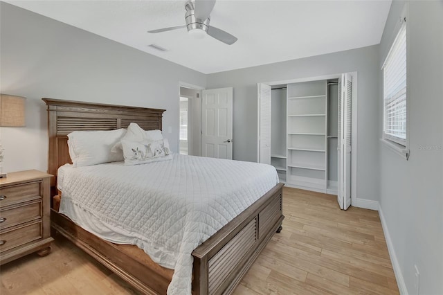 bedroom featuring light wood finished floors, baseboards, visible vents, ceiling fan, and a closet