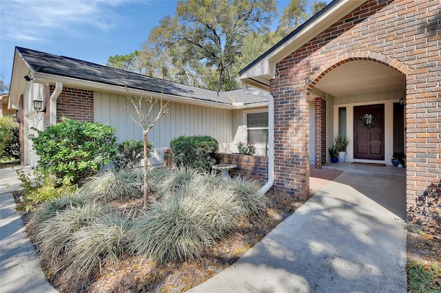 view of exterior entry featuring brick siding