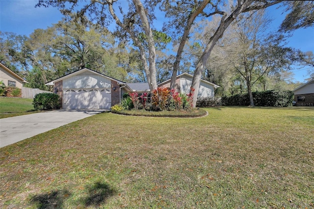 view of front of home with brick siding, concrete driveway, fence, a garage, and a front lawn