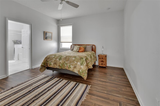 bedroom featuring a ceiling fan, ensuite bath, baseboards, and wood finished floors