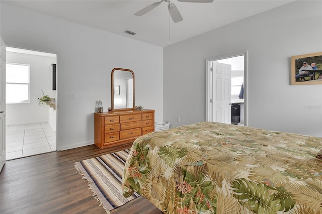 bedroom featuring baseboards, visible vents, connected bathroom, ceiling fan, and wood finished floors