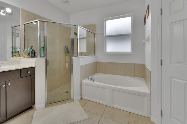 bathroom with tile patterned flooring, a shower stall, a bath, and vanity