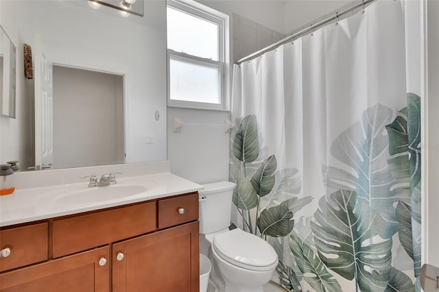 bathroom featuring toilet, a shower with shower curtain, and vanity