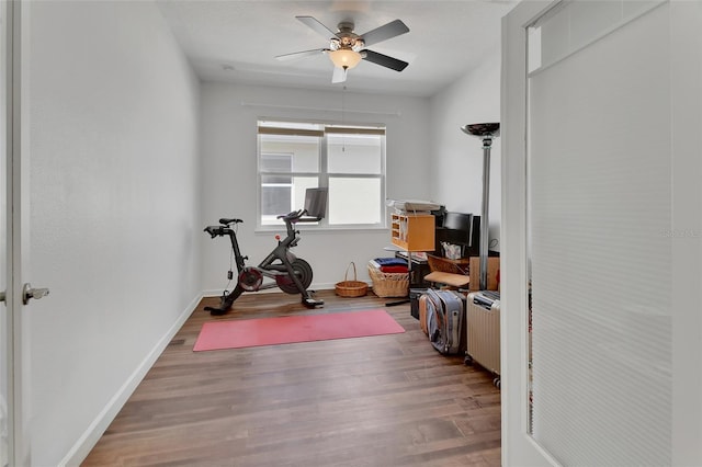 workout room with radiator heating unit, ceiling fan, baseboards, and wood finished floors