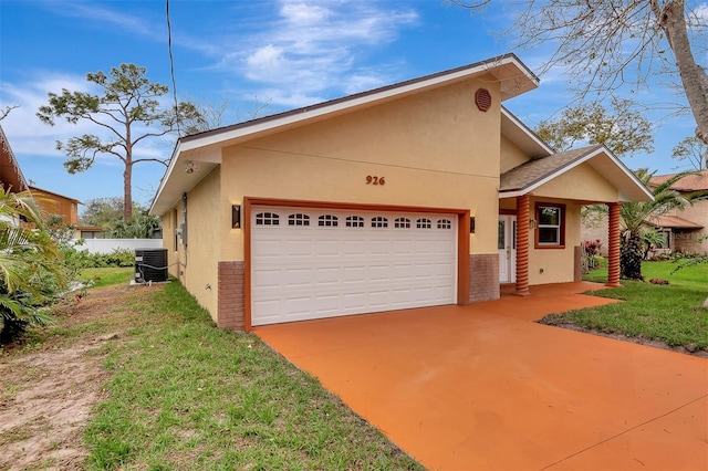 view of front of house with a garage, central air condition unit, a front lawn, and stucco siding