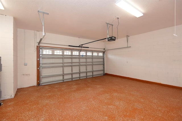 garage featuring a garage door opener and concrete block wall