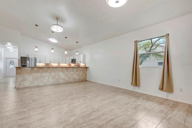 interior space with lofted ceiling and baseboards