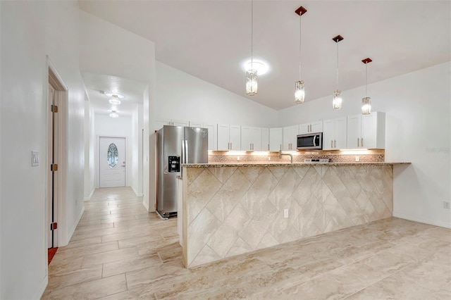 kitchen featuring light stone counters, pendant lighting, stainless steel appliances, decorative backsplash, and white cabinets