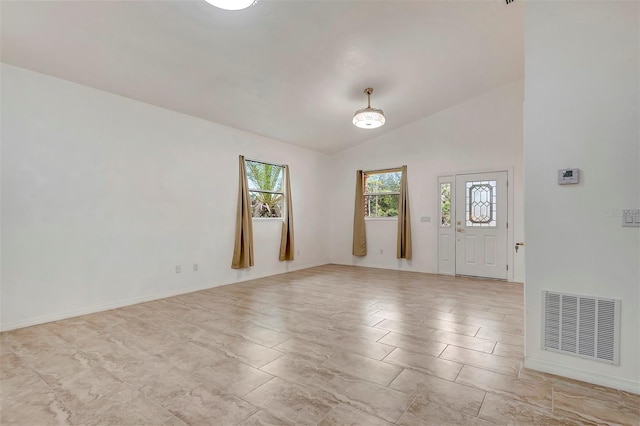 unfurnished room with baseboards, visible vents, and vaulted ceiling