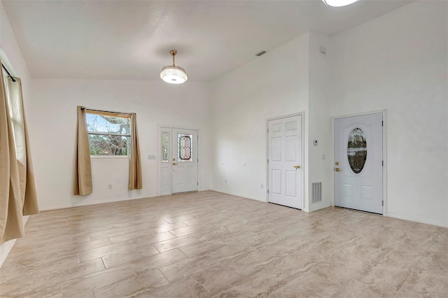 entryway featuring a high ceiling, visible vents, and baseboards