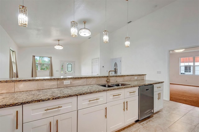 kitchen featuring stainless steel dishwasher, a sink, light stone counters, and decorative light fixtures