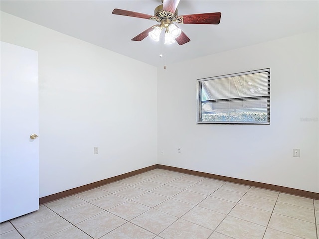 spare room featuring light tile patterned floors, baseboards, and a ceiling fan