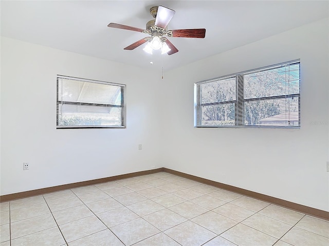 unfurnished room with baseboards, a ceiling fan, and light tile patterned flooring