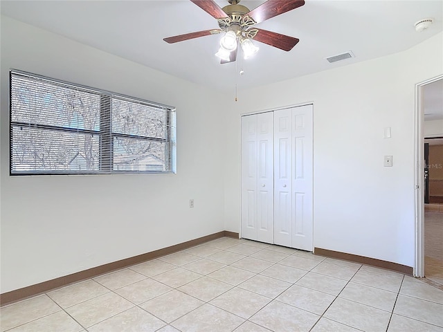 unfurnished bedroom with a closet, visible vents, baseboards, and light tile patterned floors