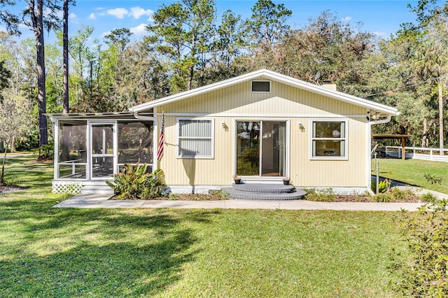 view of front of property with a front yard and a sunroom