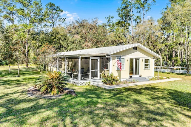 view of front of house with a front lawn, fence, and a sunroom