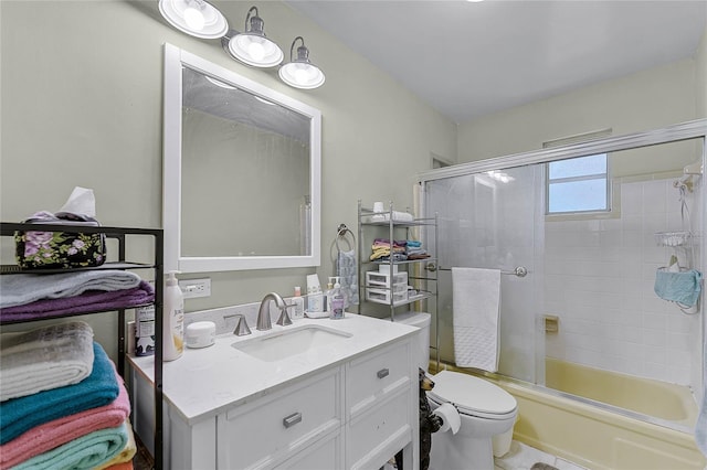 bathroom featuring vanity, toilet, and bath / shower combo with glass door