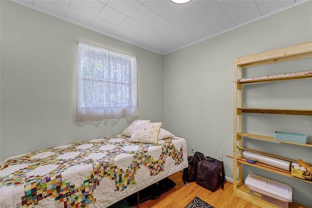 bedroom with crown molding and wood finished floors