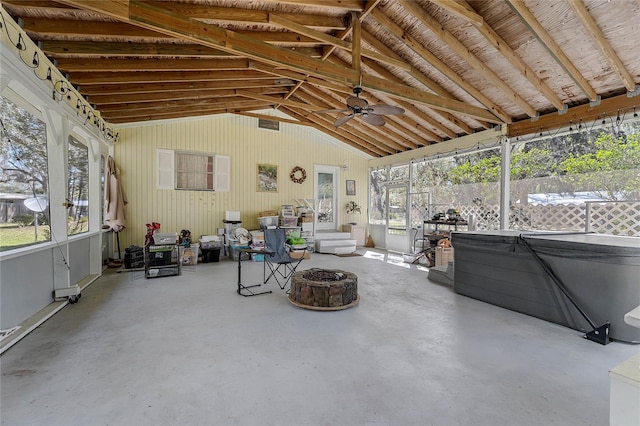 unfurnished sunroom featuring ceiling fan, vaulted ceiling, and a wealth of natural light