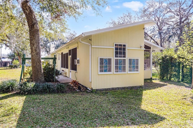 view of home's exterior with fence, a lawn, and a patio