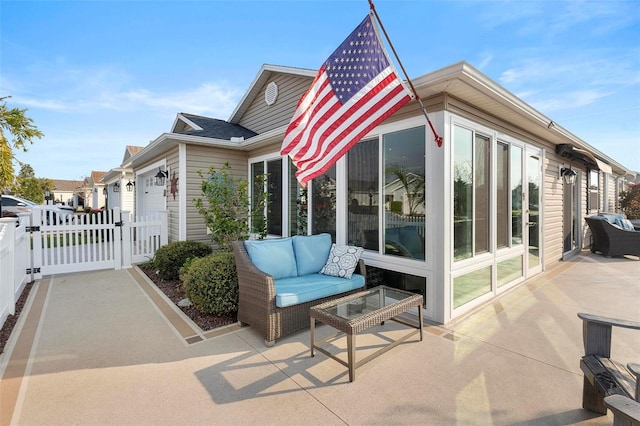 view of home's exterior with a garage, a patio area, a gate, and fence