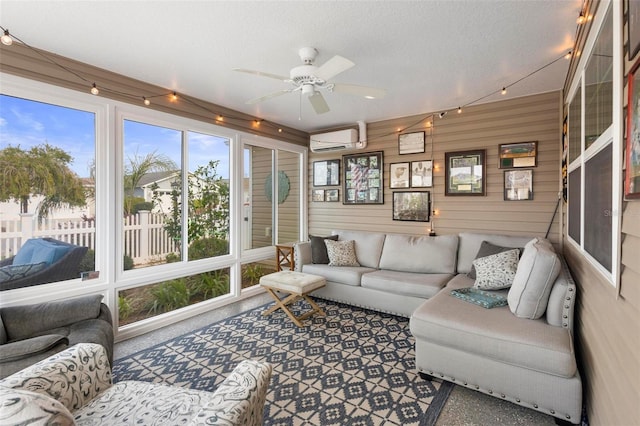 sunroom featuring a wall unit AC and a ceiling fan