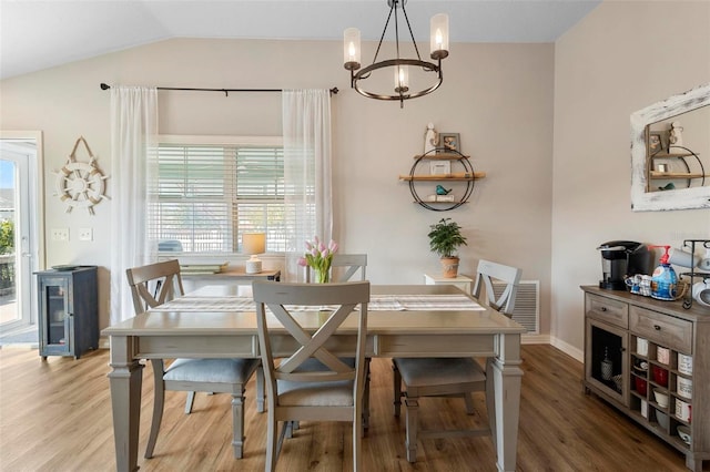 dining area with lofted ceiling, wood finished floors, visible vents, and baseboards