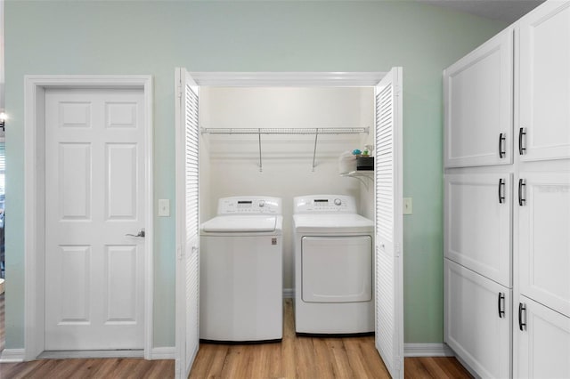 washroom with laundry area, light wood finished floors, independent washer and dryer, and baseboards