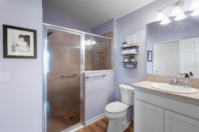 full bath featuring toilet, wood finished floors, vanity, vaulted ceiling, and a shower stall