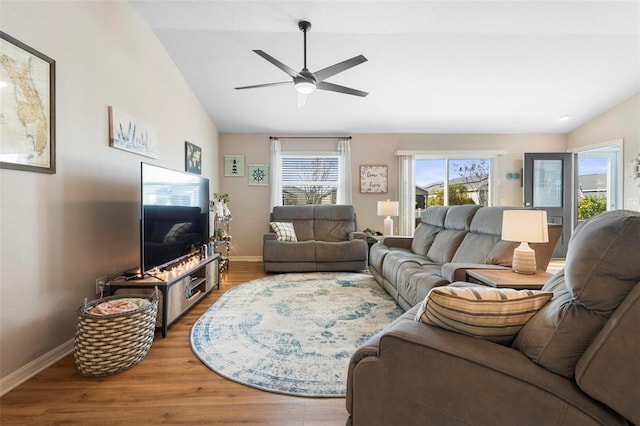 living area with lofted ceiling, wood finished floors, a ceiling fan, and baseboards