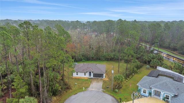 birds eye view of property featuring a forest view