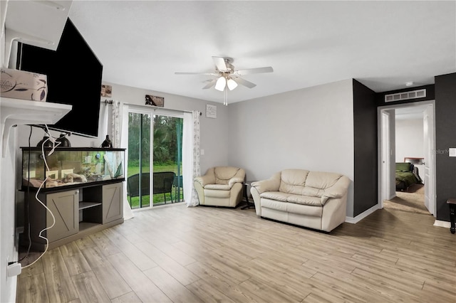 sitting room featuring baseboards, visible vents, ceiling fan, and light wood finished floors