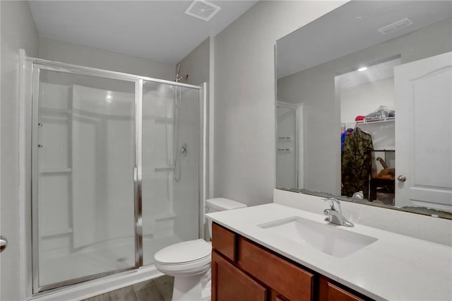 full bathroom featuring vanity, a shower stall, and visible vents