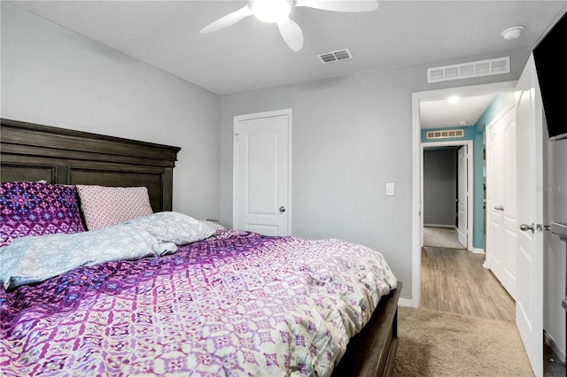 carpeted bedroom featuring a ceiling fan, visible vents, and baseboards