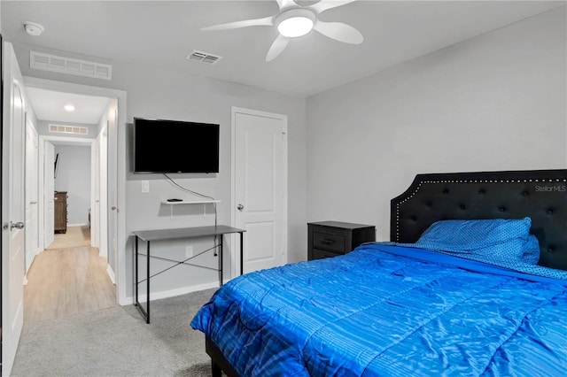 bedroom featuring a ceiling fan, light colored carpet, visible vents, and baseboards